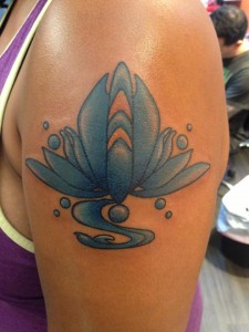 Image of Jemisin's left shoulder with tattoo of a stylized blue lotus